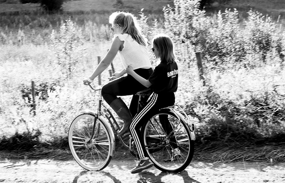 Jenter og hjelm. Heldigvis er de to på sykkelen.